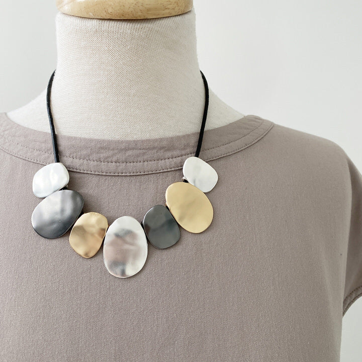 COLLIER AVEC PIÈCES MÉTALLIQUES TEXTURÉES AU FINI USÉ SUR CORDE DE CUIR VÉRITABLE ET ATTACHE AIMANTÉ - OR, ARGENT ET HÉMATITE | NECKLACE WITH TEXTURED METALLIC PIECES IN WORN FINISH ON GENUINE LEATHER CORD WITH A MAGNET CLOSURE - GOLD, SILVER & HEMATITE