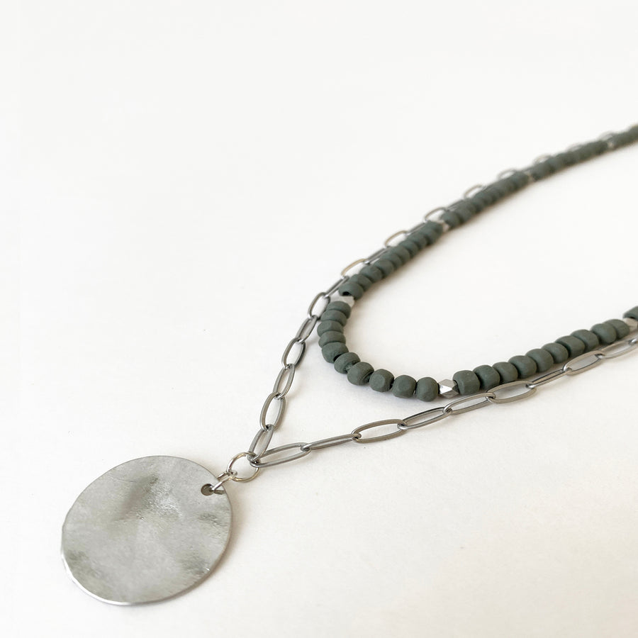 COLLIER 2 RANGS AVEC BILLES DE BOIS ET PENDENTIF PASTILLES ONDULÉES MÉTALLIQUE - GRIS ET ARGENT | 2 ROWS NECKLACE WITH WOOD BEADS & ROUND WAVED METAL PENDANT - GREY & SILVER